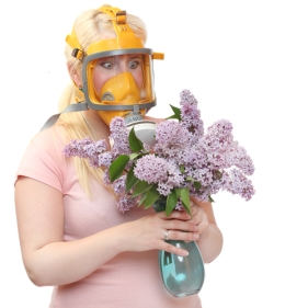Allergy to pollen concept. Young woman in protection mask with bunch of flower.